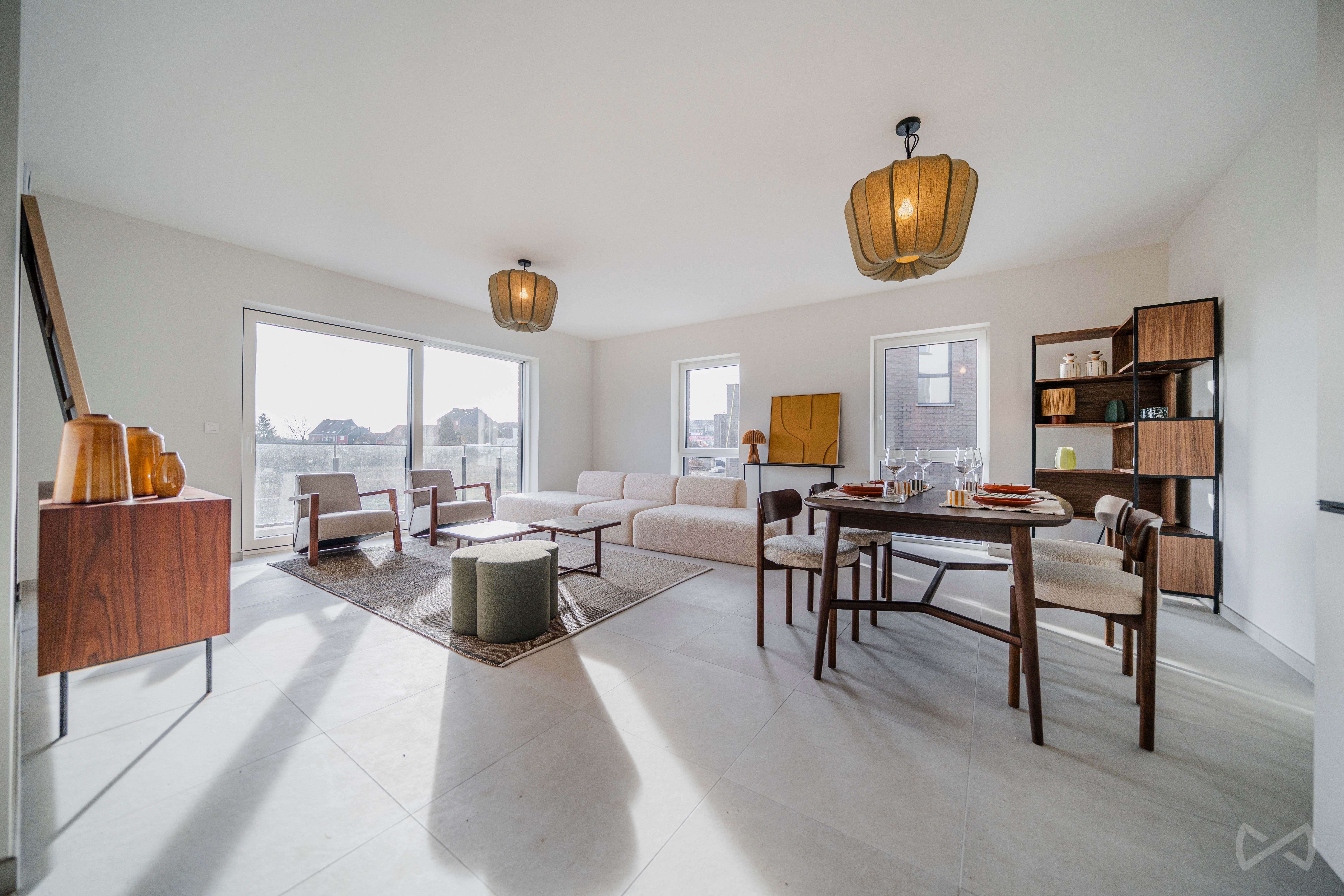 Séjour lumineux avec salon et salle à manger ouverts, aménagés dans un style moderne et épuré. De grandes fenêtres apportent une belle luminosité et offrent une vue dégagée sur l’extérieur.