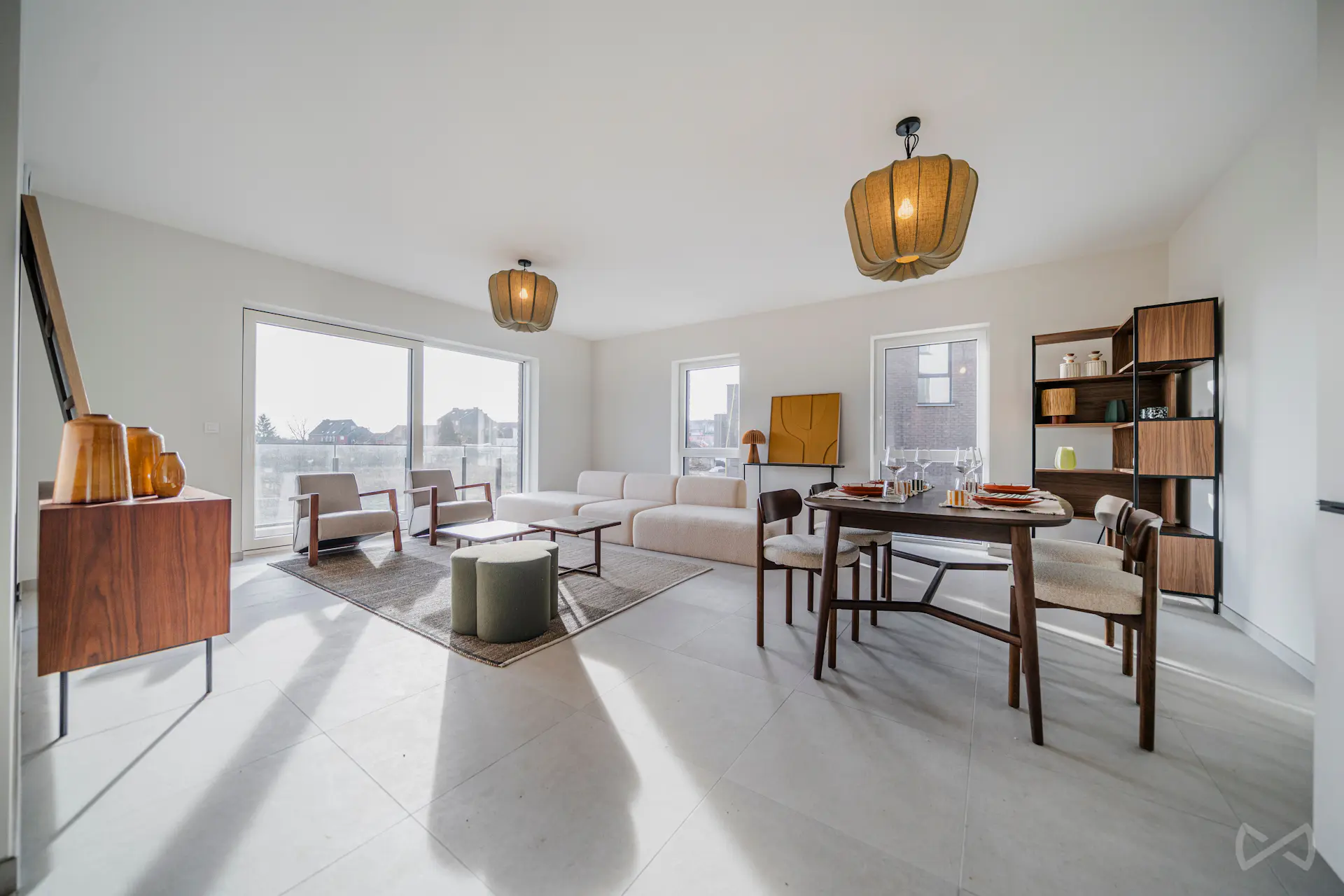 Séjour lumineux avec salon et salle à manger ouverts, aménagés dans un style moderne et épuré. De grandes fenêtres apportent une belle luminosité et offrent une vue dégagée sur l’extérieur.