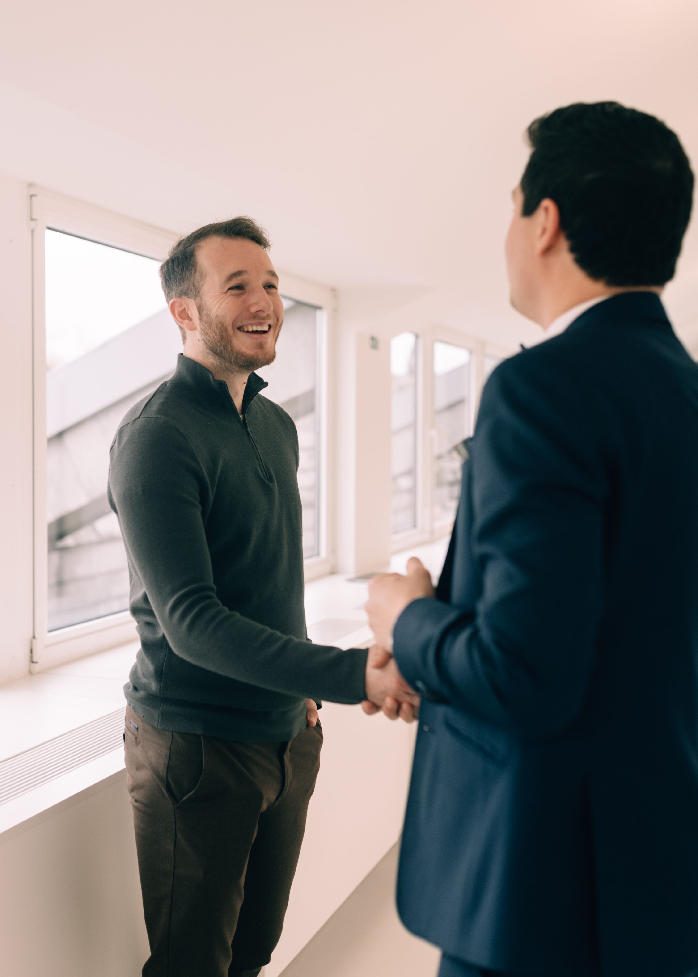 Klant en vastgoedmakelaar, geven elkaar een handdruk na een succesvolle vastgoedtransactie.