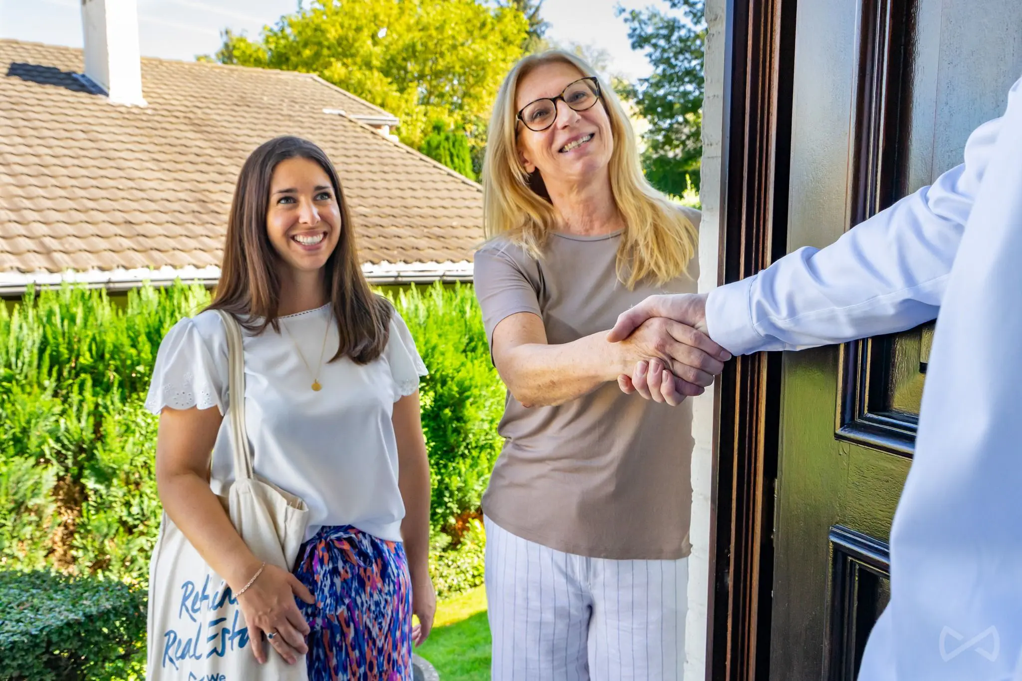 Agent immobilier We Invest tendant sa carte de visite à un potentiel vendeur pendant sa prospection.