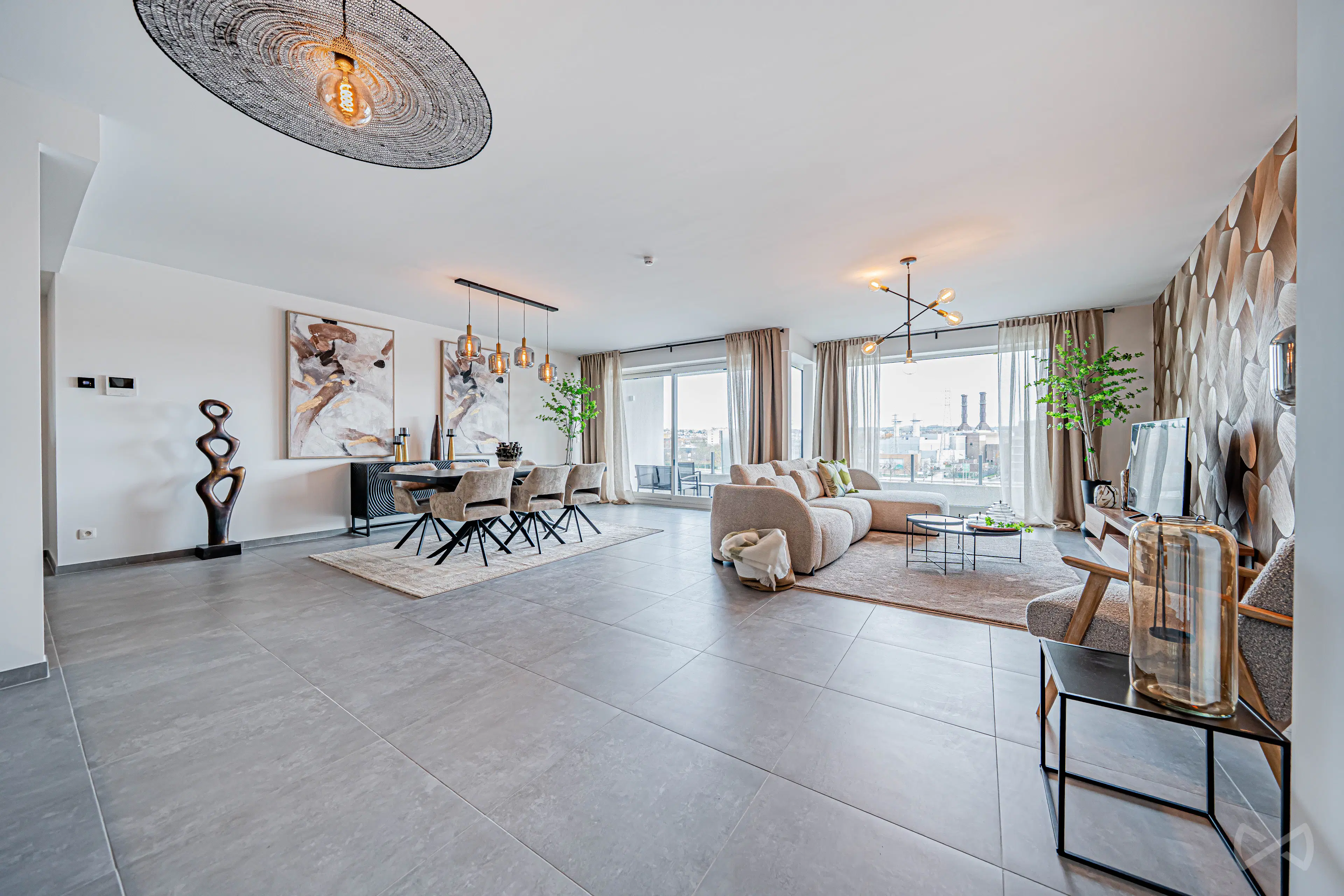 Grand séjour contemporain ouvert, combinant salon et salle à manger avec mobilier aux tons neutres et matériaux chaleureux. De larges baies vitrées apportent une forte luminosité et offrent une vue dégagée sur l’extérieur.