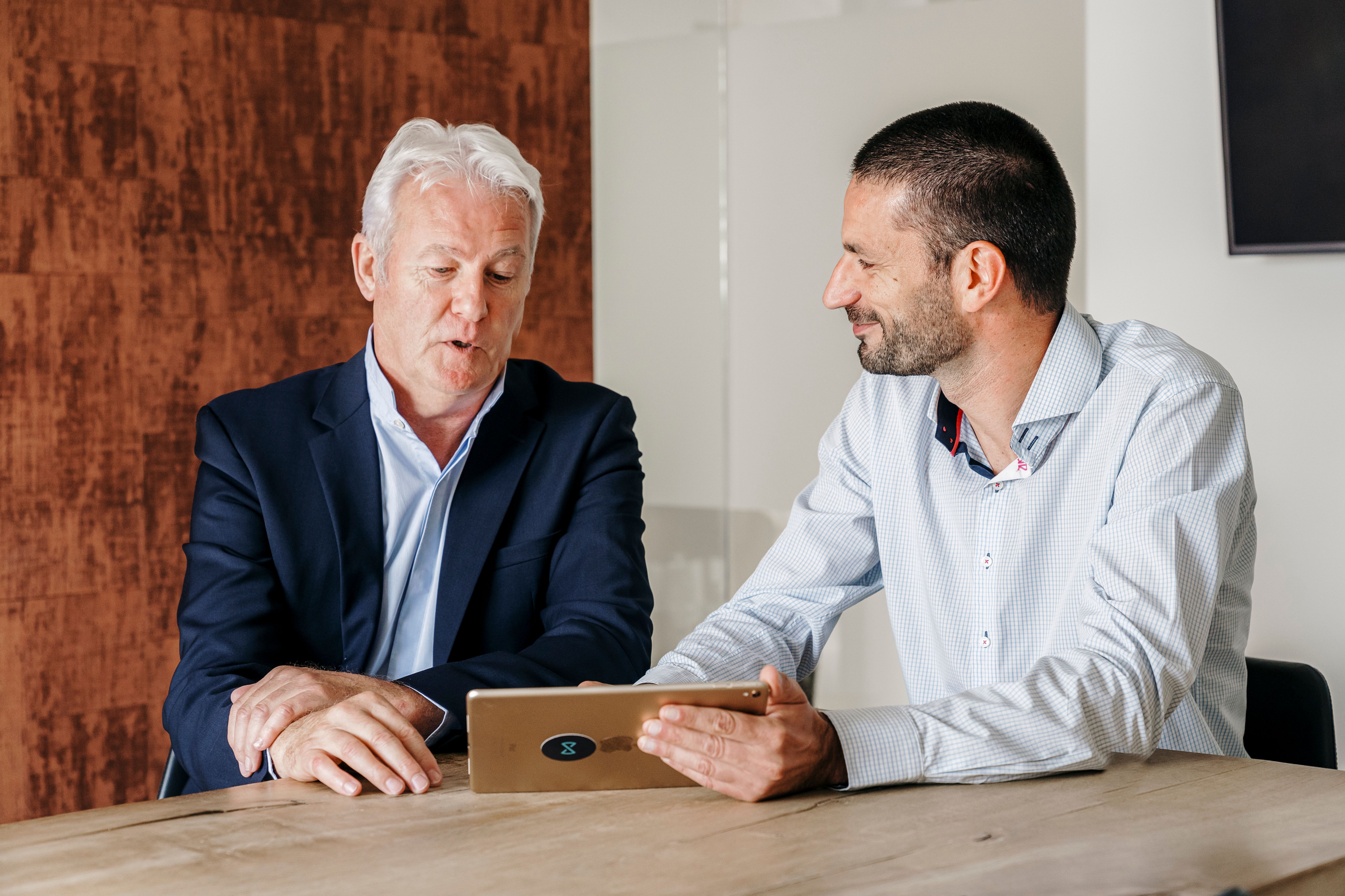 We Invest real estate agent explains the selling steps to a house owner on a couch.