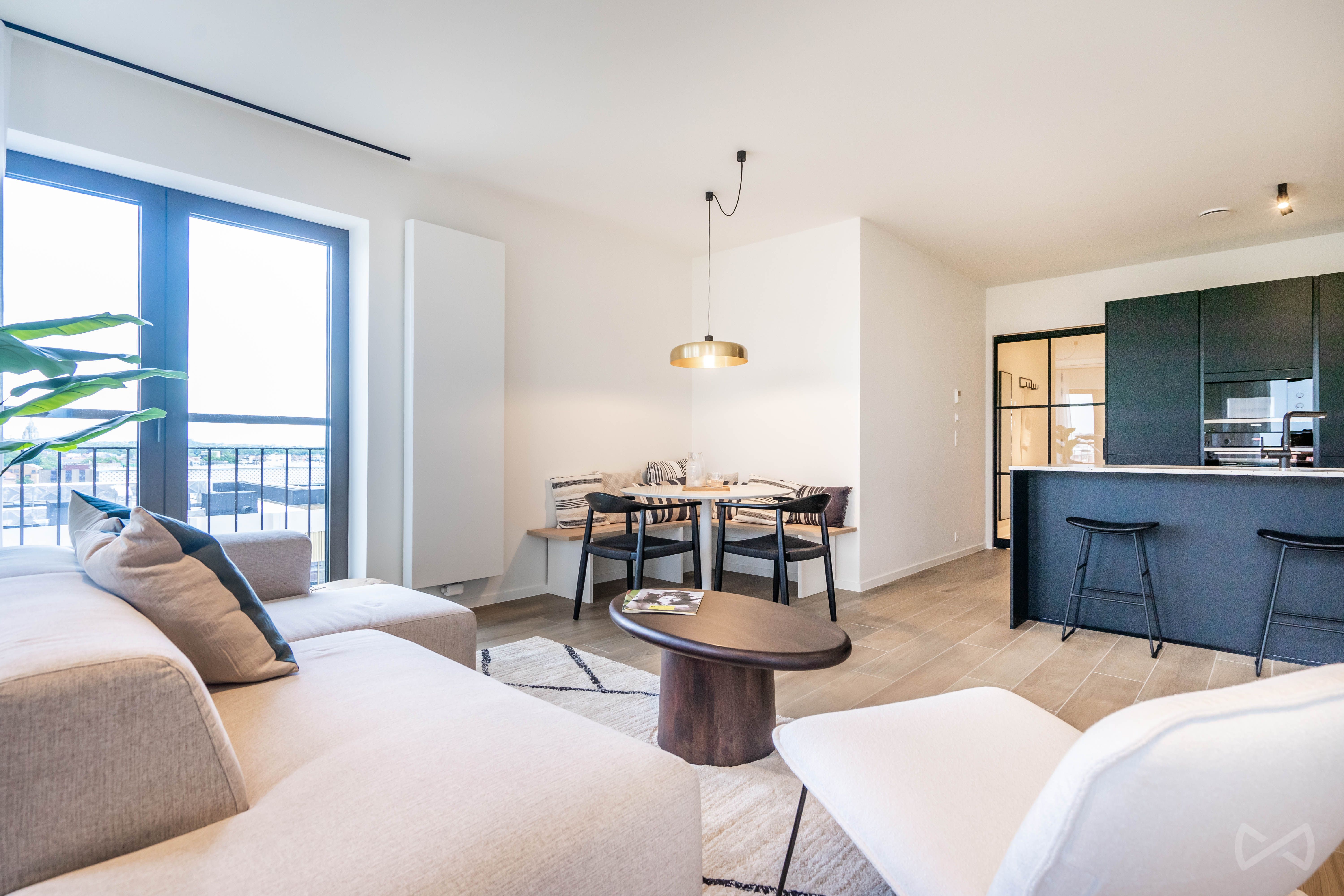 Espace de vie dans un appartement à Bruxelles. L'image montre un salon et une cuisine en arrière plan