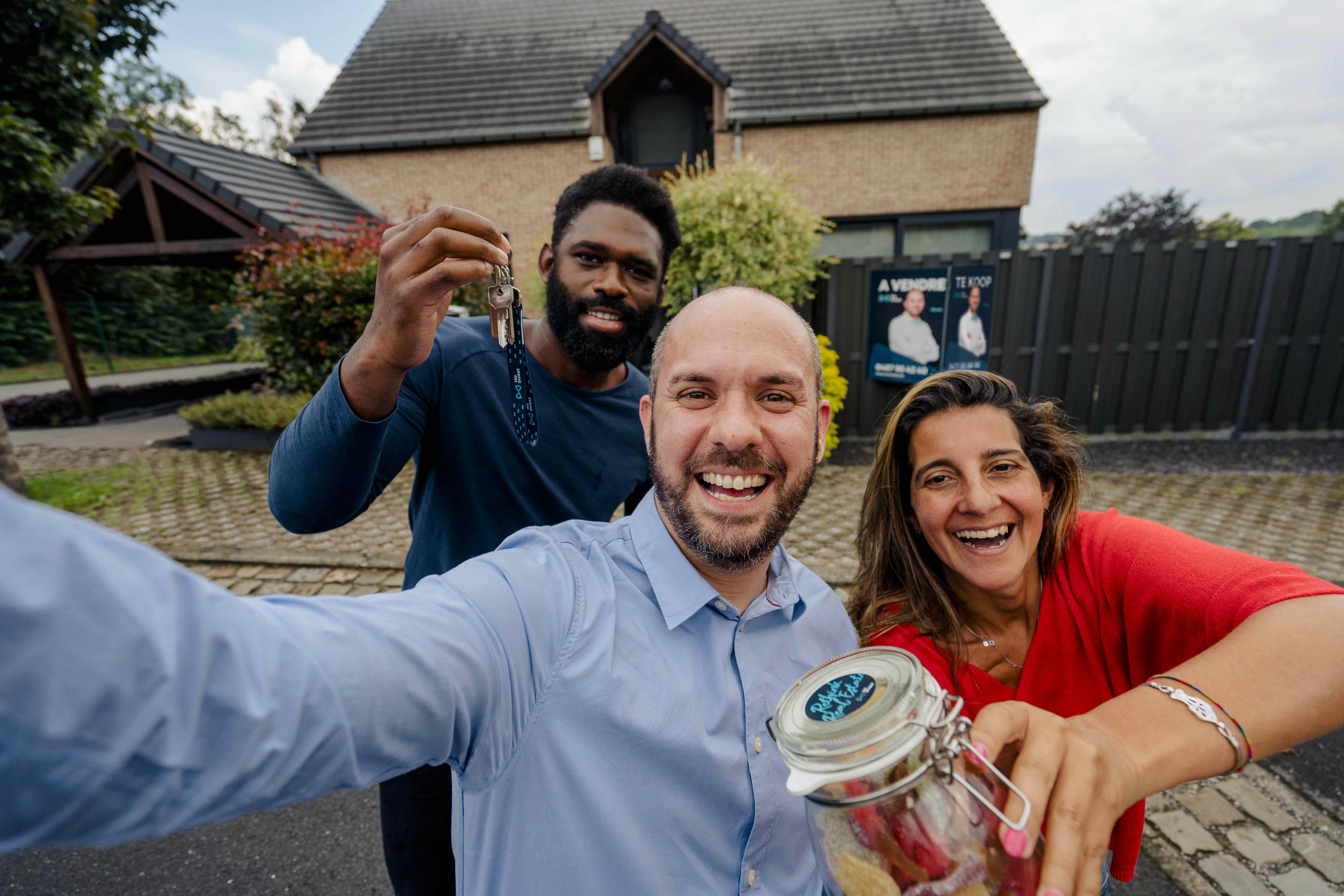 Selfie avec agent et propriétaires heureux pour célébrer la vente de leur maison grâce à un conseiller We Invest local.
