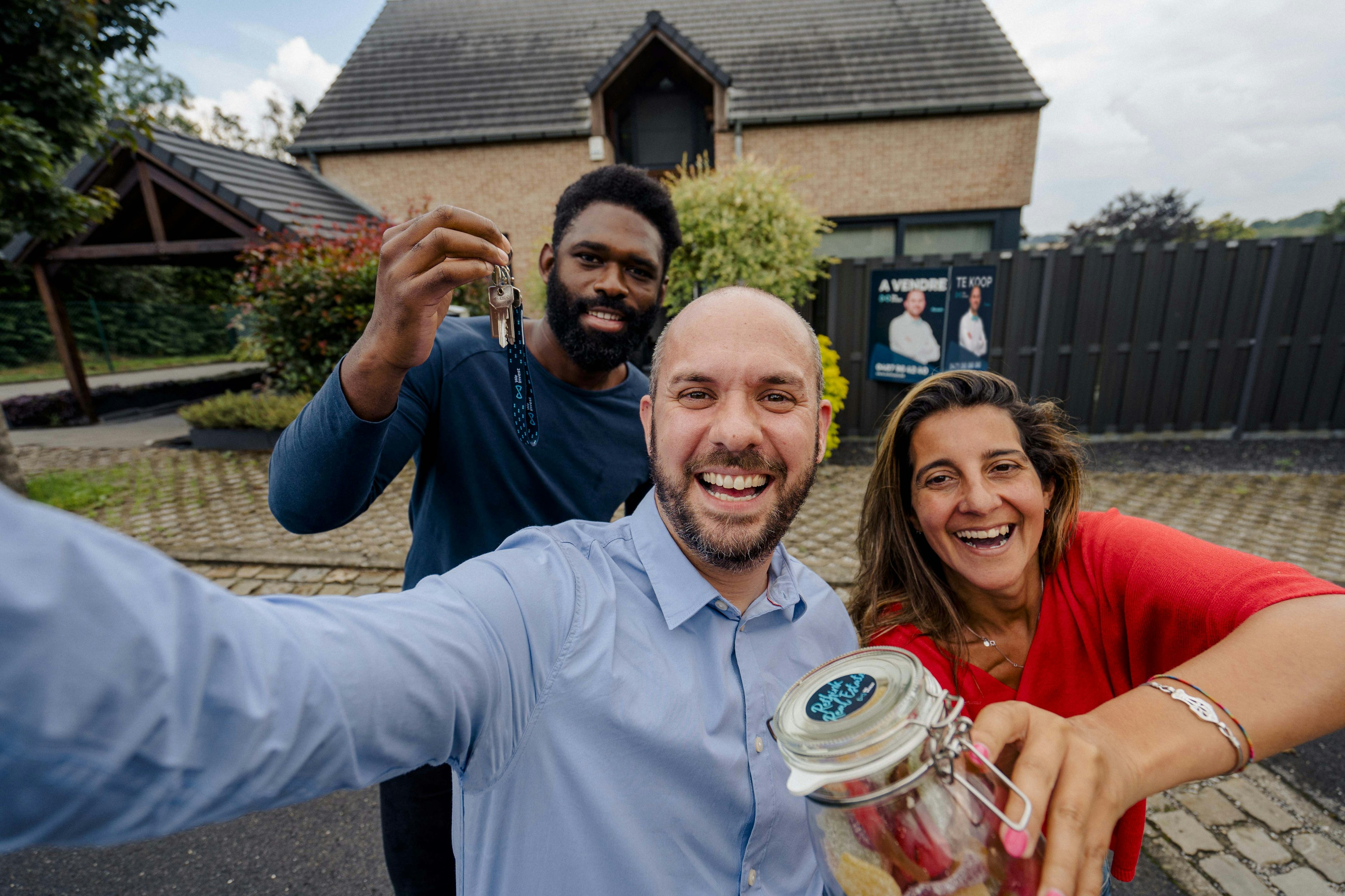 Selfie van een We Invest makelaar met gelukkige verkopers om de verkoop van hun huis te vieren