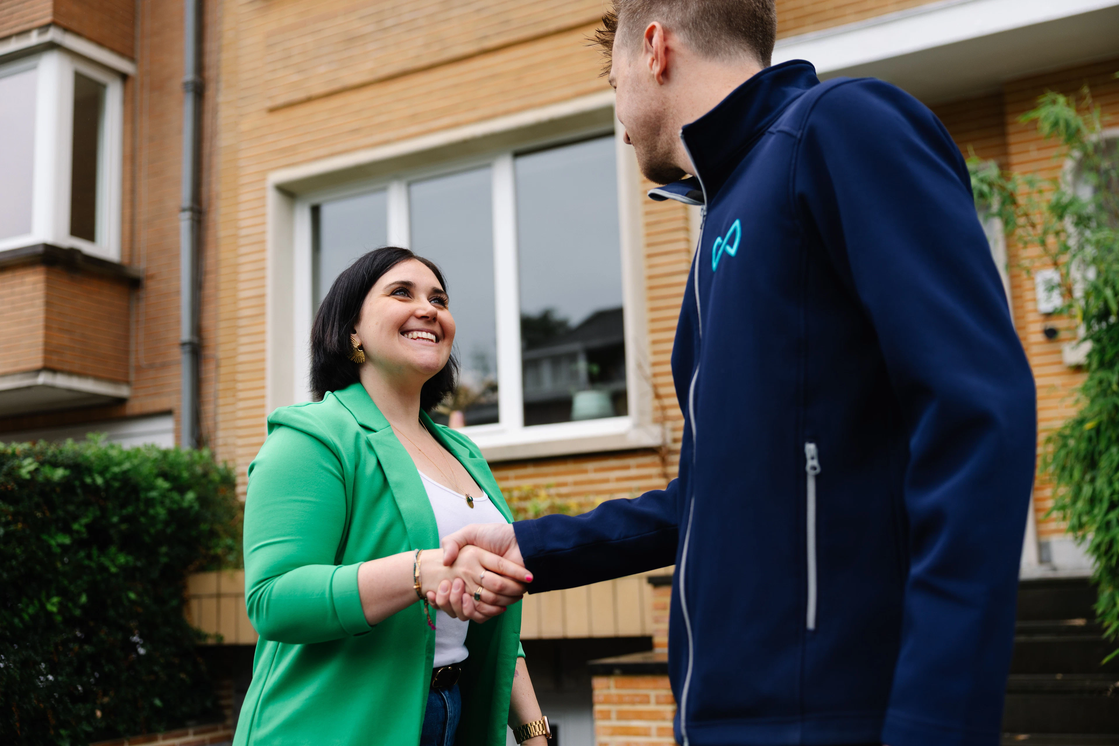 Agent immobilier We Invest accueillant des clients pour une visite immobilière à Schaerbeek
