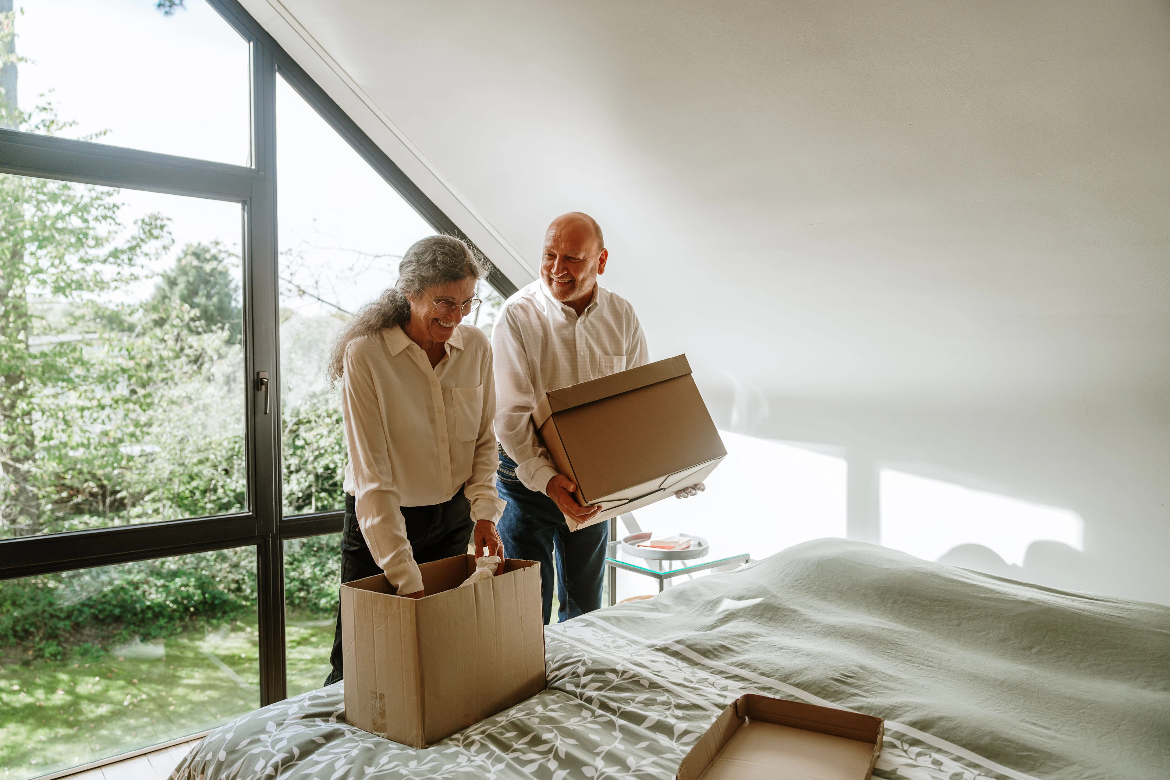 Couple de retraités préparant des cartons pour vendre une maison à Ourthe-Amblève